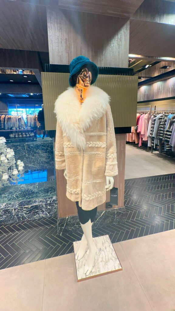 Luxury shopper examining genuine cashmere fabric texture, softness, elasticity, and fiber quality to identify authentic cashmere knitwear.